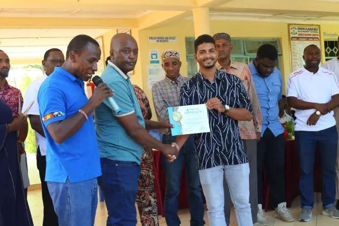 Shikaadabu Secondary School principal receiving a certificate.